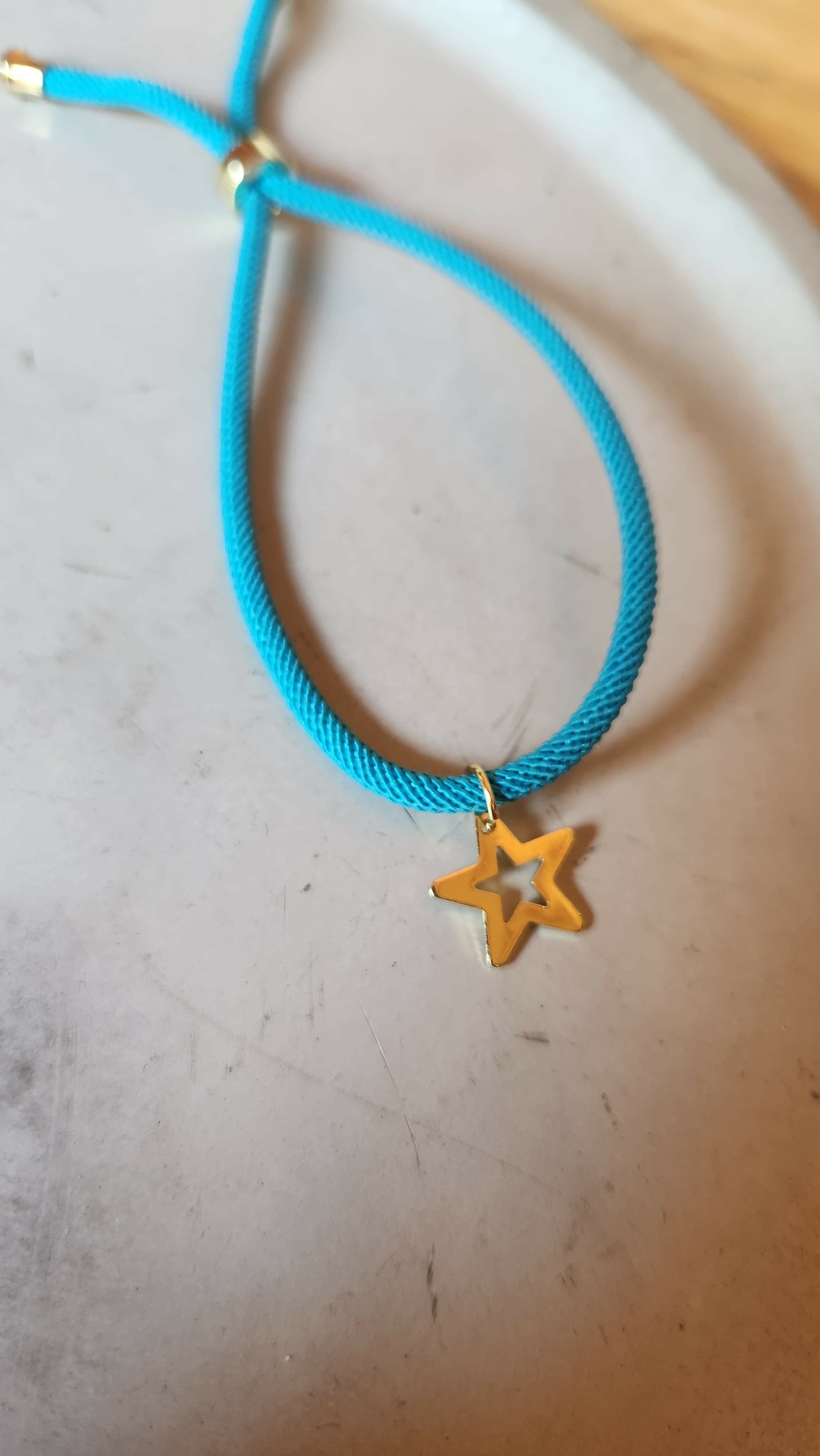 Pulsera celeste tejida con estrella solo borde baño oro