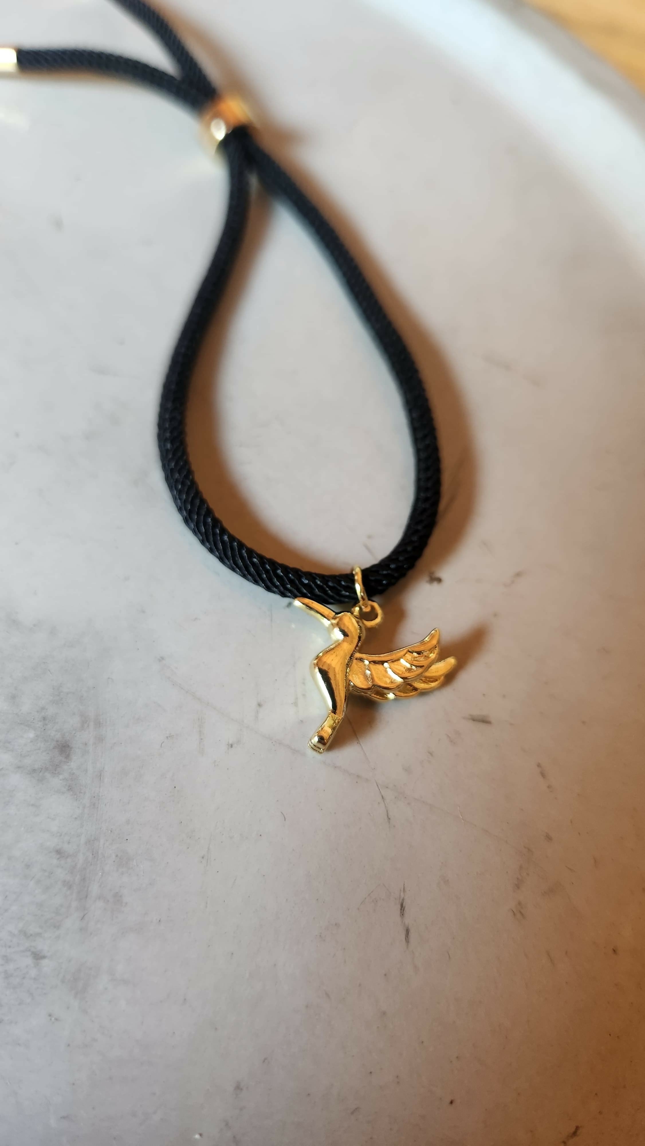 Pulsera negra tejida con colibri baño oro
