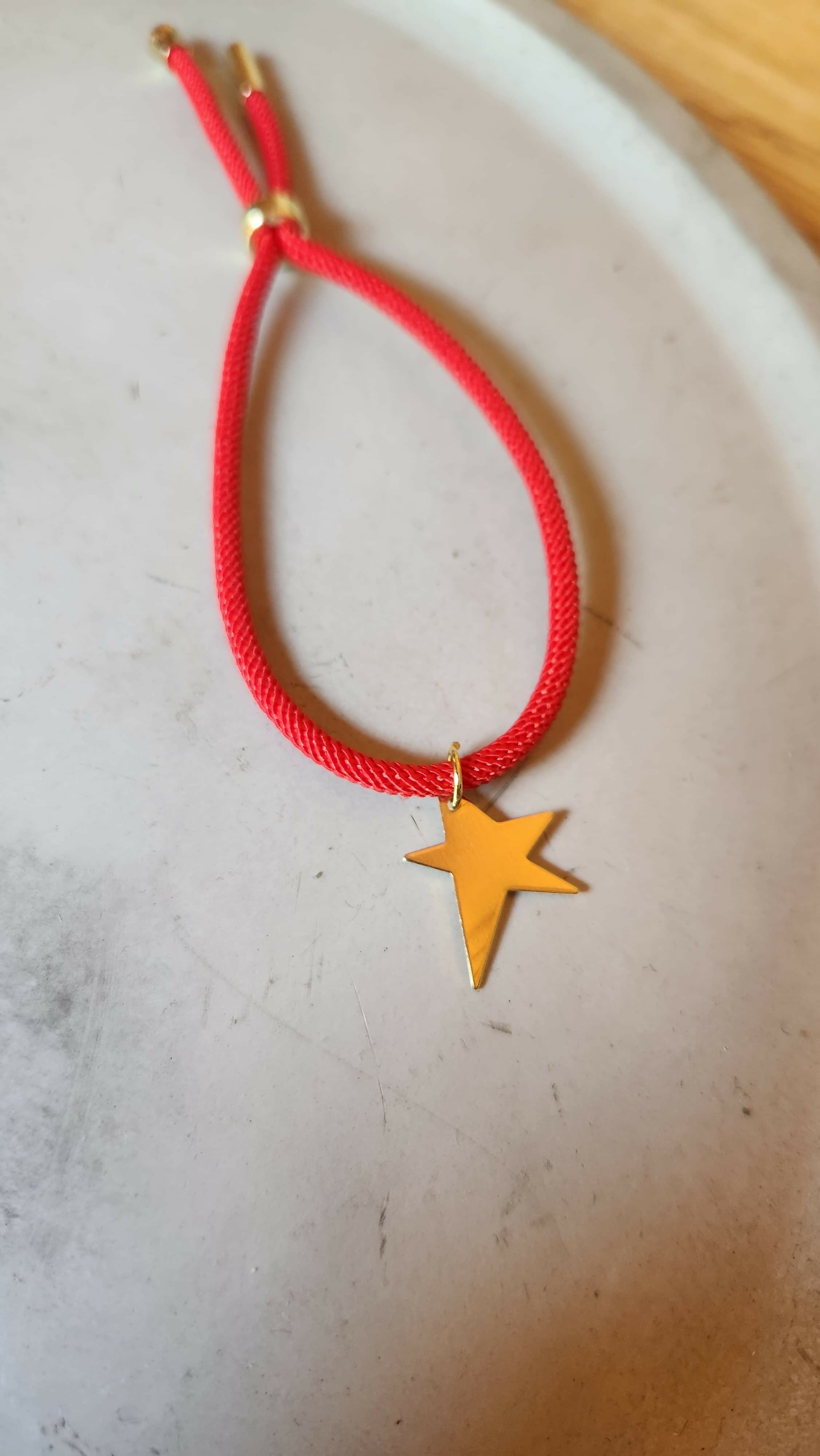 Pulsera roja tejida con estrella baño oro