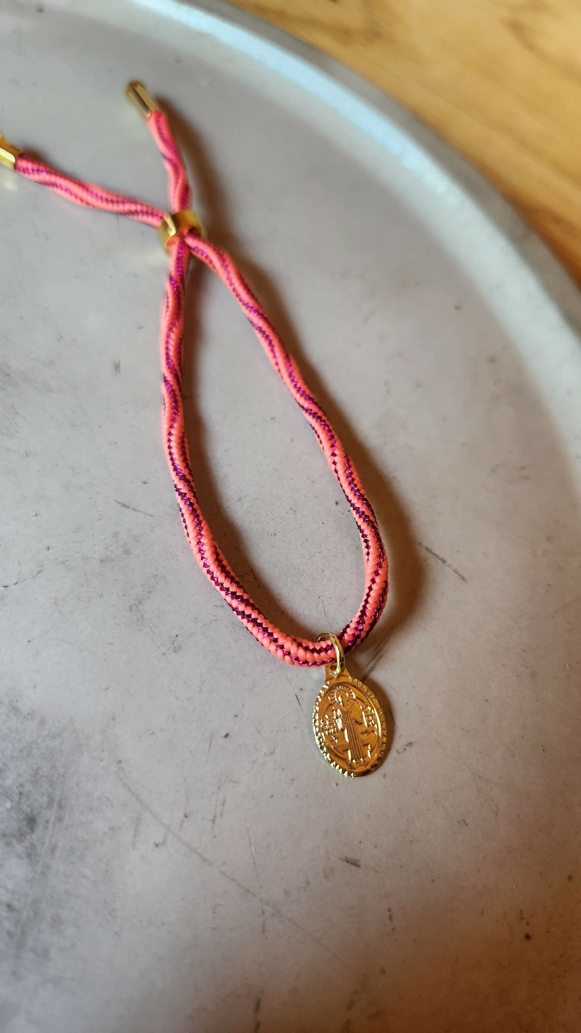 Pulsera fucsia tejida con Virgen de los Rayos baño oro