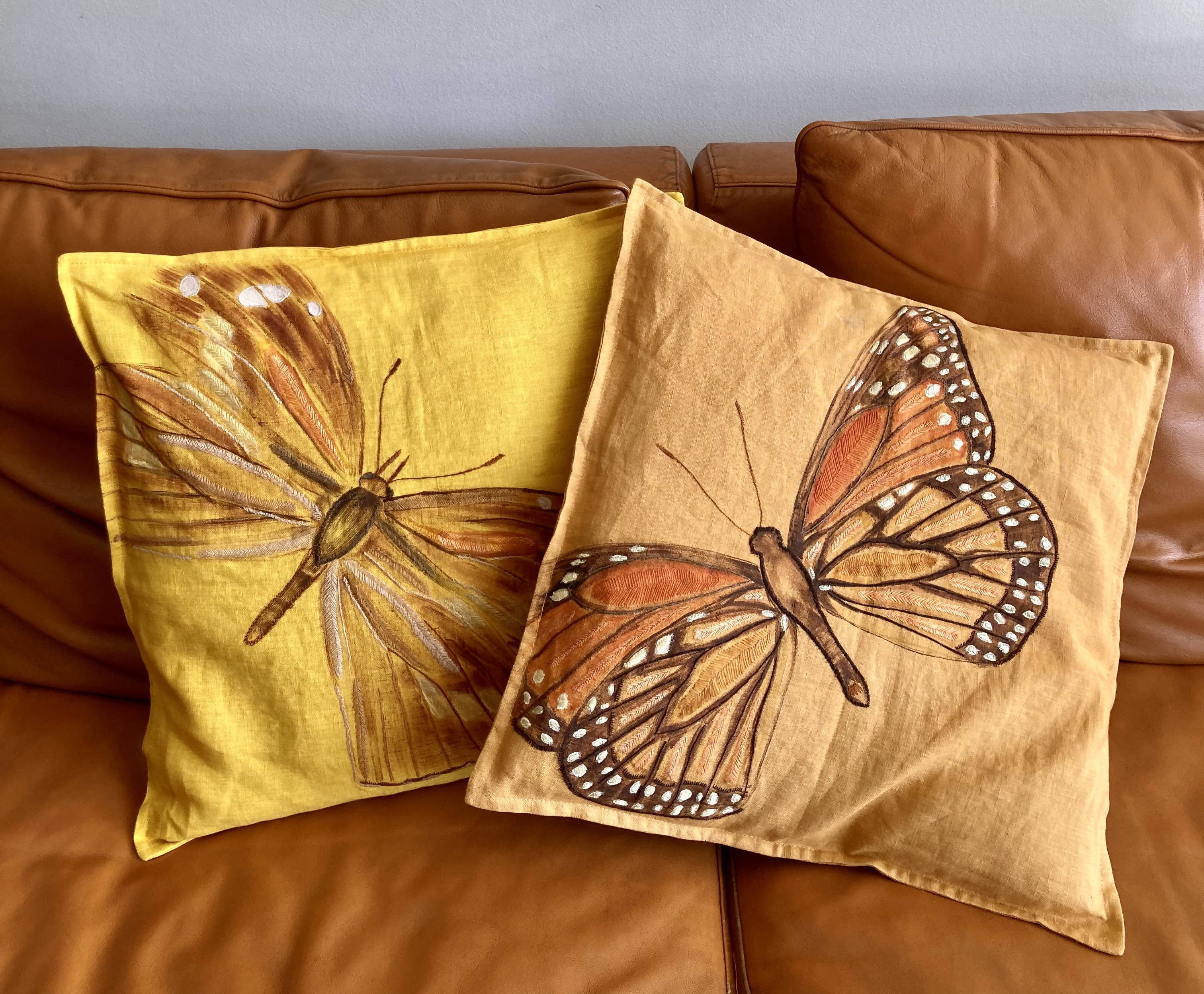 Funda cojin lino teñido a mano con mariposa chilena Monarca pintada y bordada - color naranjo claro